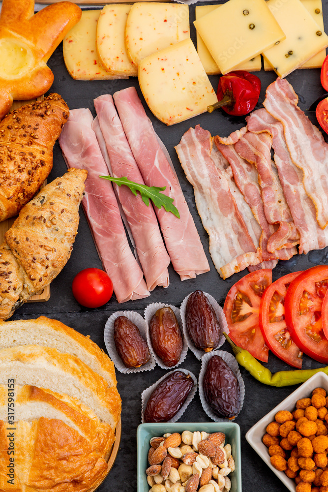 Breakfast on the table. Croissant bread, Croissant cereal, Bacon, ham, cheese, lettuce, beans, corn 