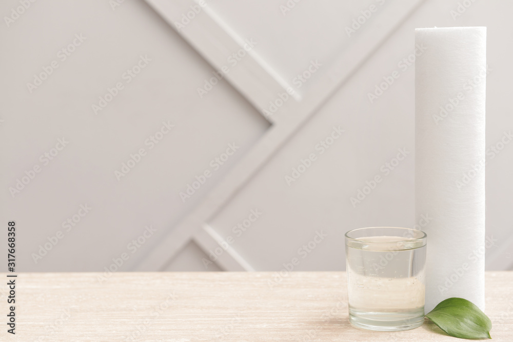 Glass of clean water and filter on table