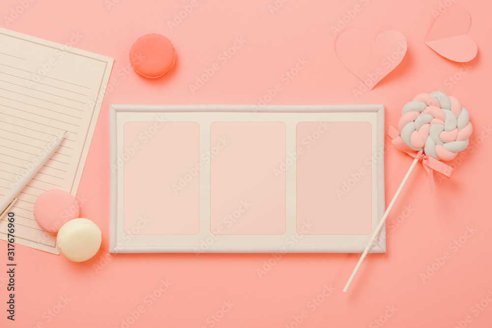 A white sheet of paper for message to loved one, candy with picture frame on pink background. Happy 