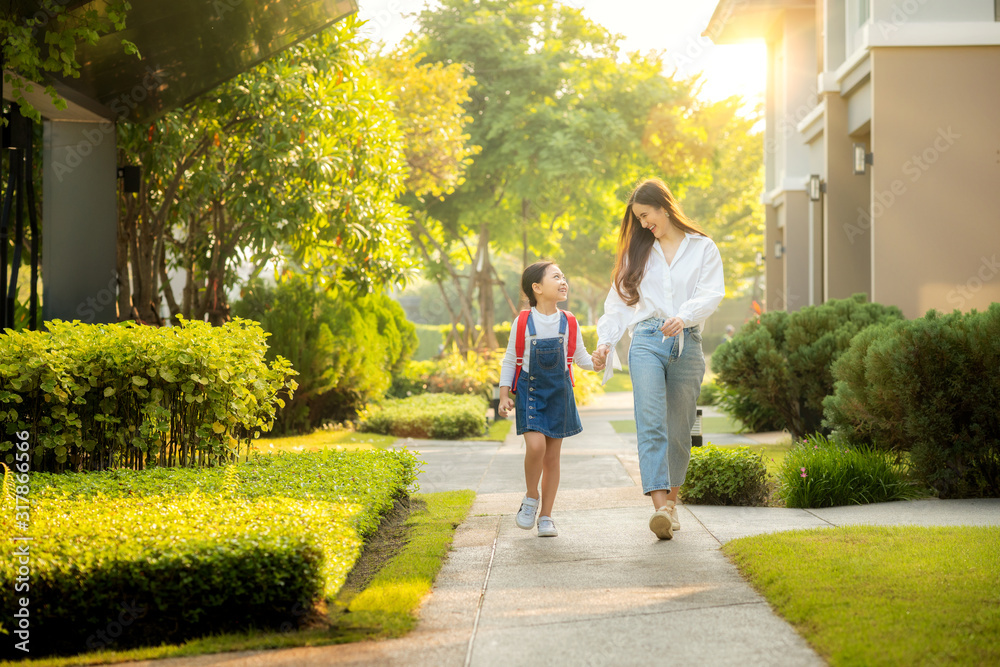 亚洲学龄前女孩和妈妈一起走路上学