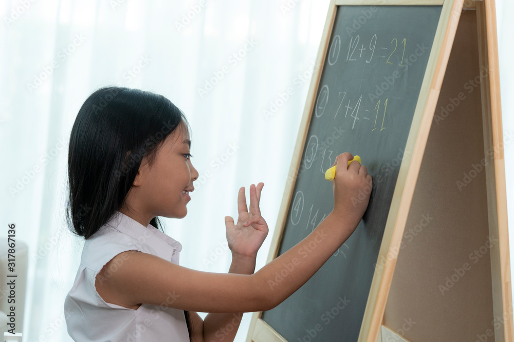 亚洲女孩在回到学校之前在篮板上写字和做家务