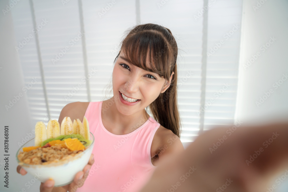 Asian girl take a selfie with clean food after exercise in fitness gym