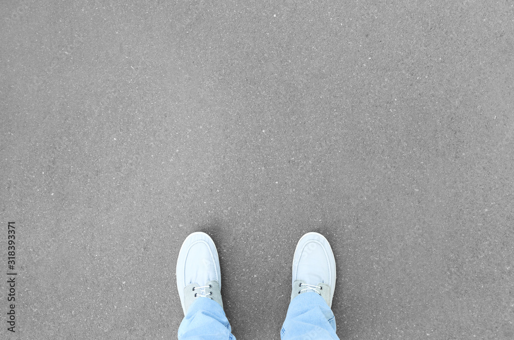 Person standing on asphalt road, top view. Concept of choice