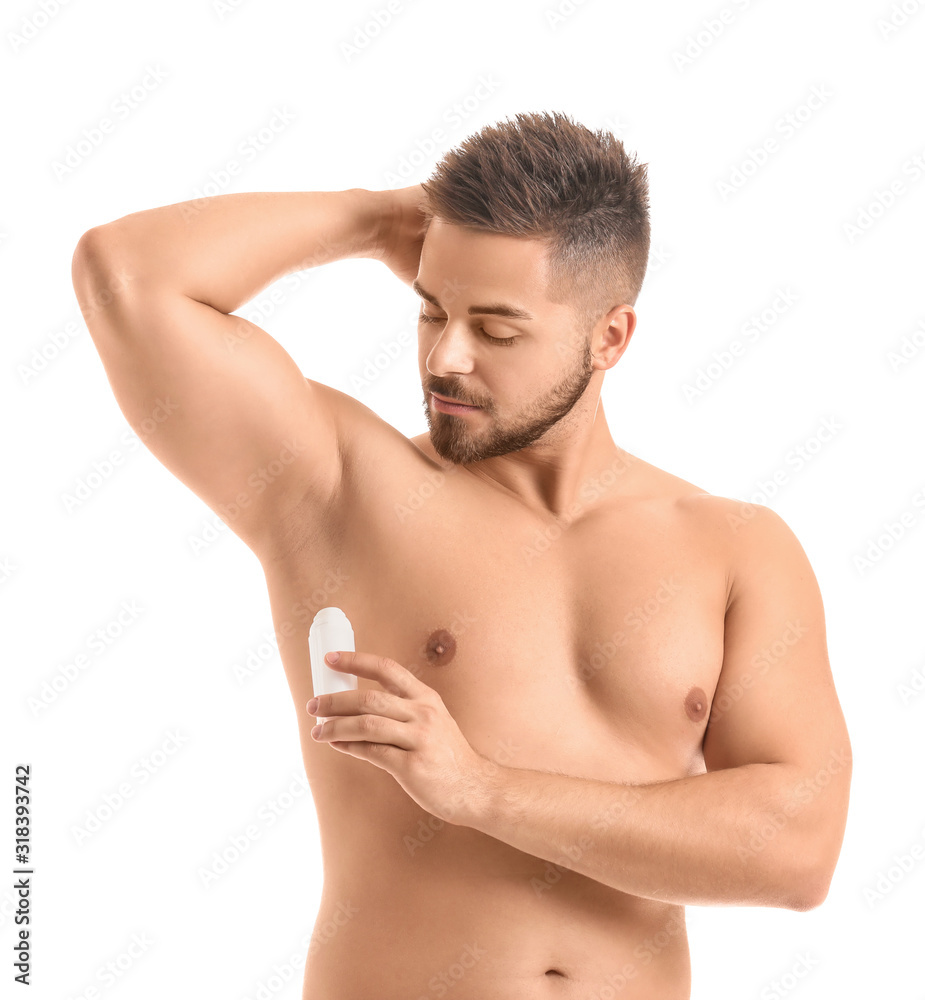 Handsome young man using deodorant on white background