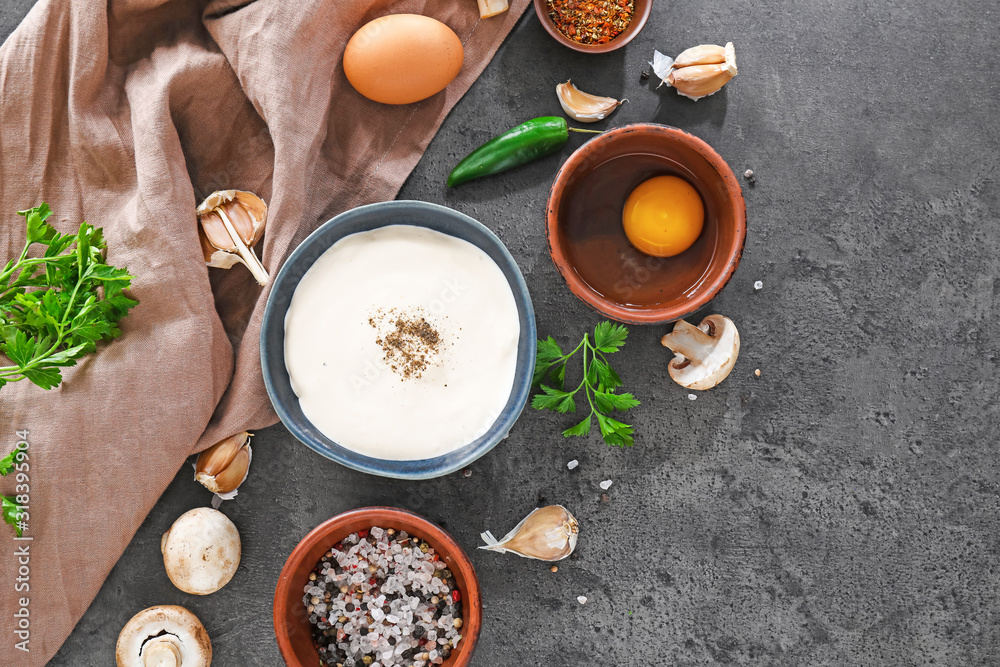 Bowl of tasty sauce with ingredients on dark background