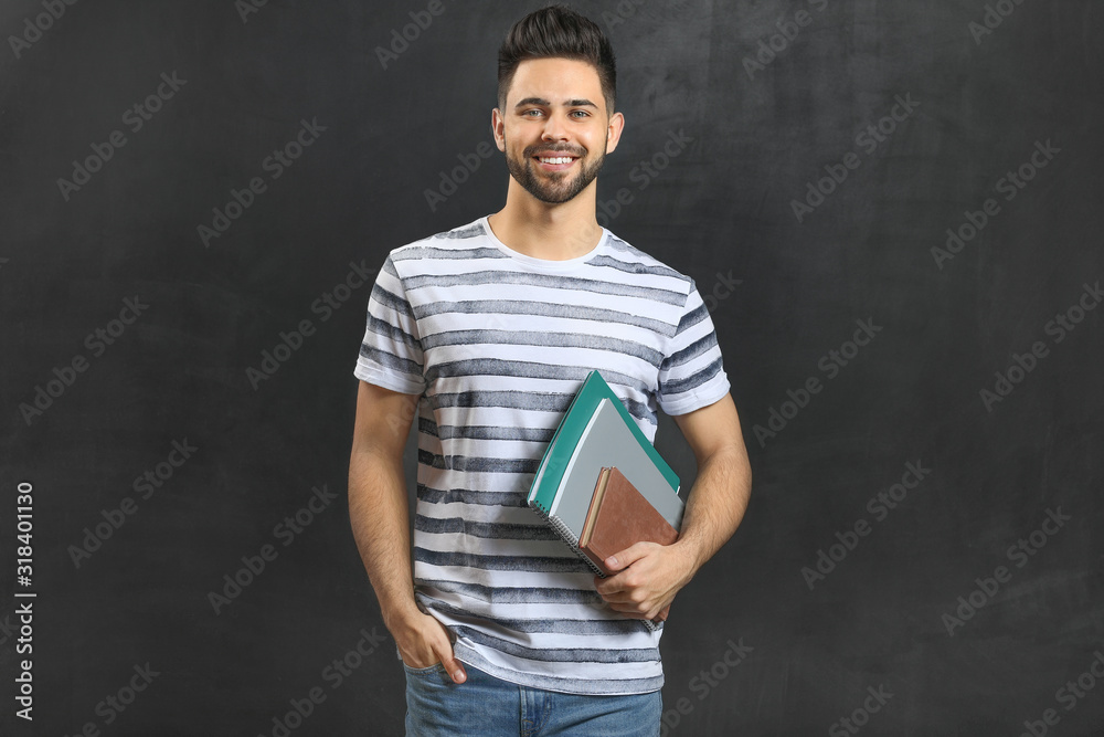 Male student near blackboard in classroom