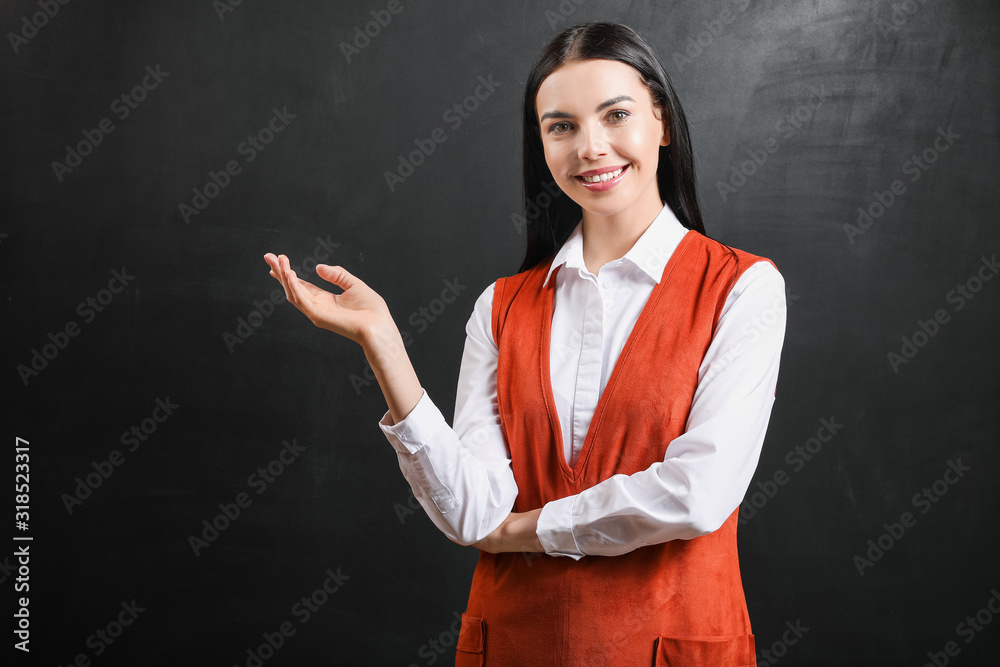 Female teacher near blackboard in classroom