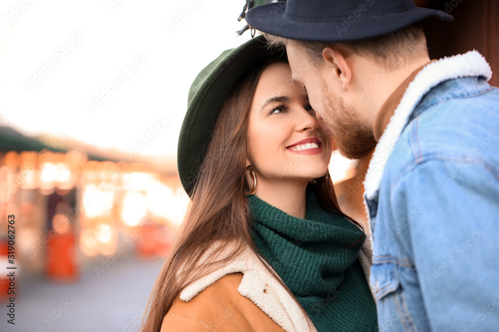 Happy young couple on Christmas fair outdoors