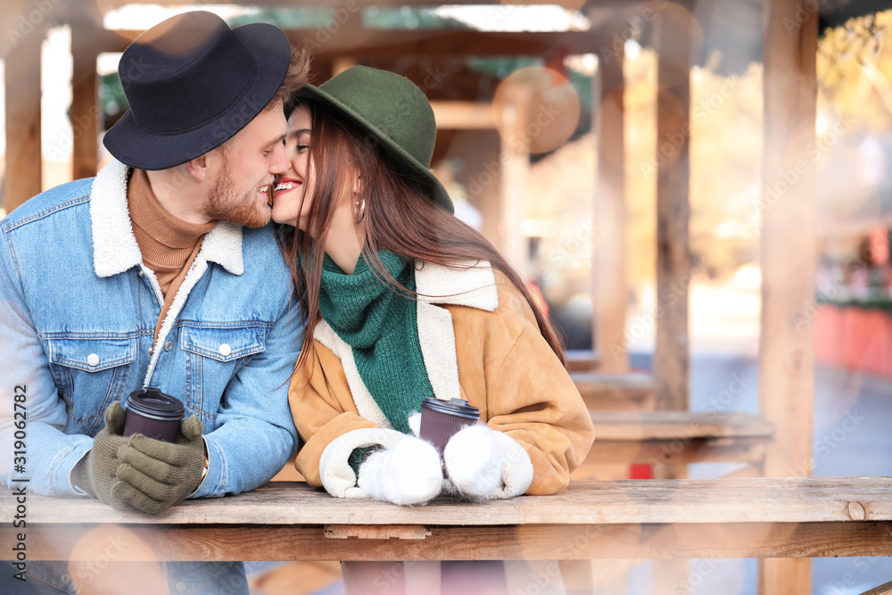 Happy young couple on Christmas fair outdoors