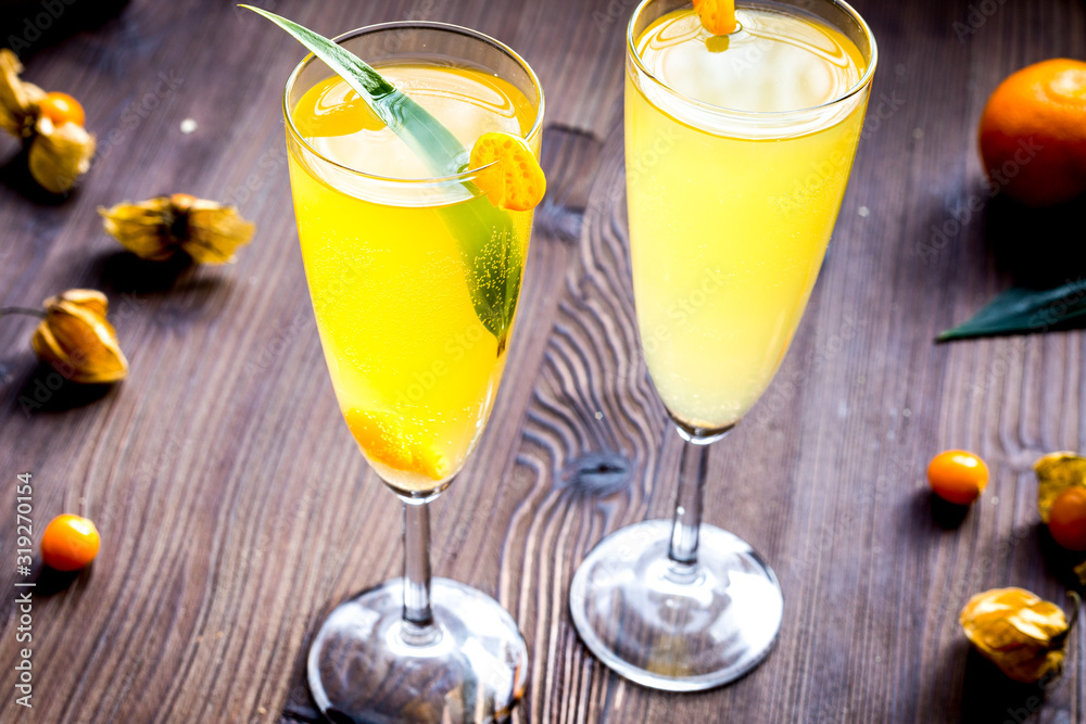 cocktail with physalis in glass on wooden background