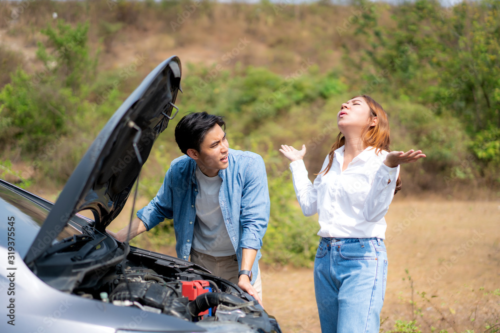 Asian young couple with man and woman on the road having problem breakdown down car engine on the ro