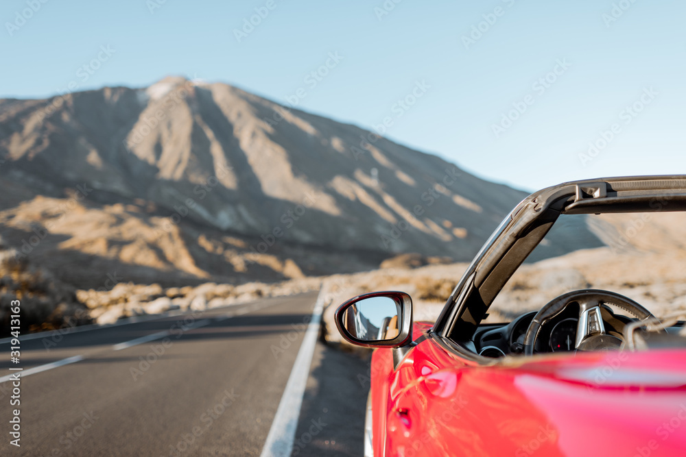 沙漠山谷路边的敞篷车，背景是火山，乘坐ca旅行