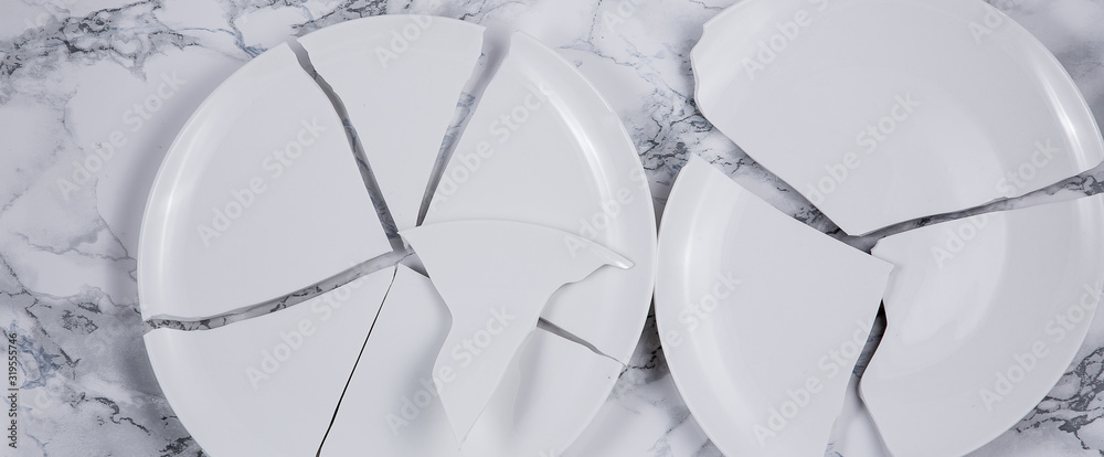 Broken white plate or Broken glass on the floor in the kitchen