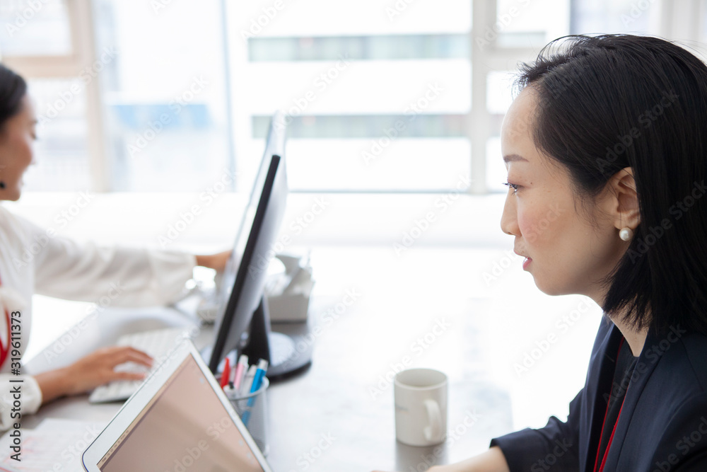 デスクワークをする女性社員たち