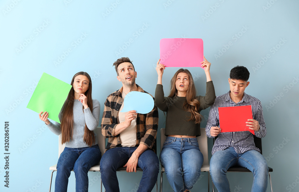 Group of young people with blank speech bubbles on color background