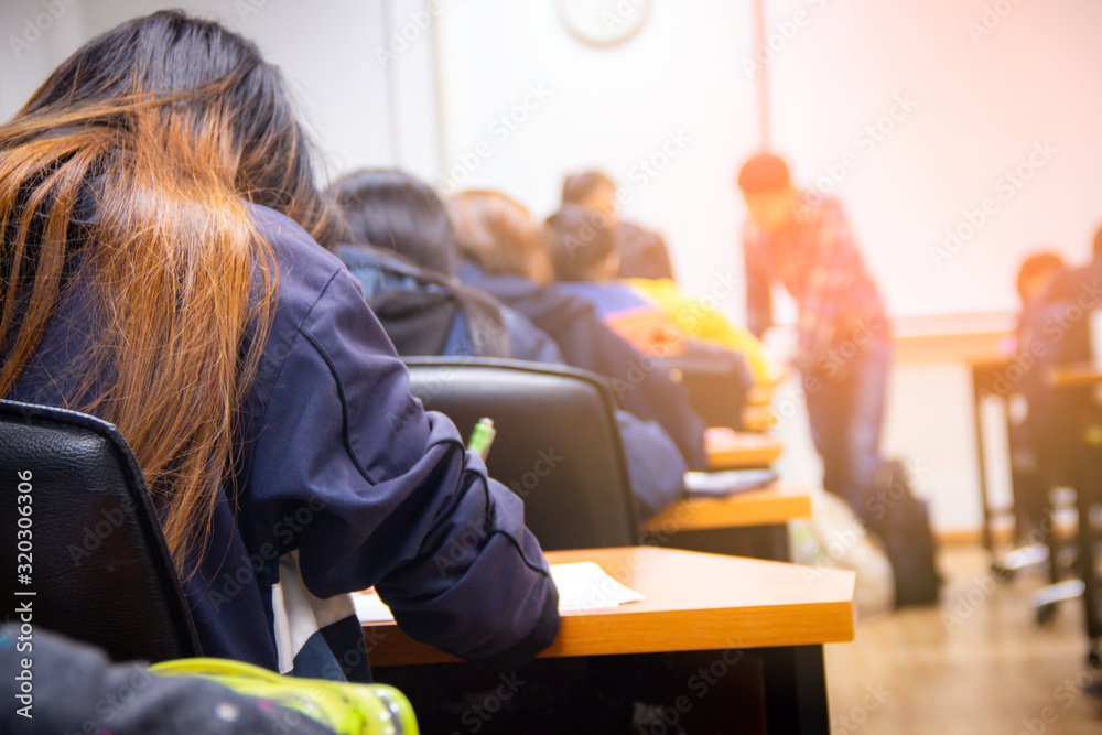 动手让大学生拿着笔写作/计算器做考试/学习或测验，测试