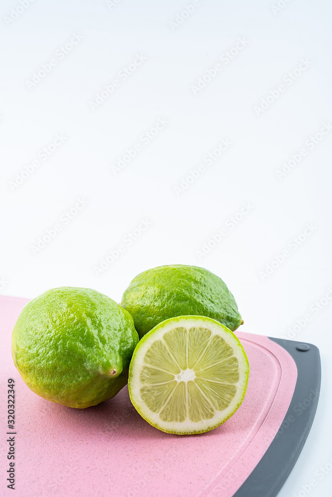 Fresh green lemon on red cutting board