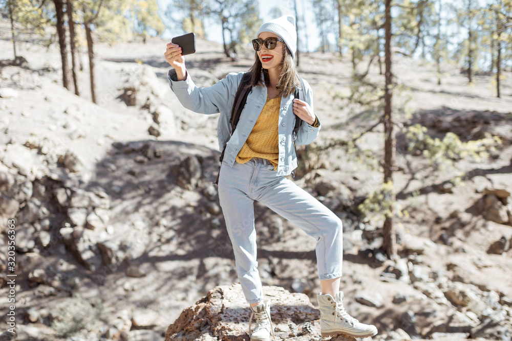 年轻女子在火山森林旅行时通过电话拍照或视频记录。生活方式t