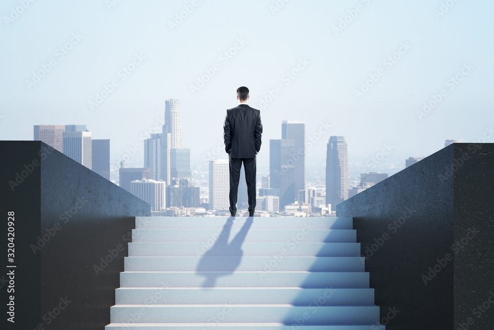 Businessman in suit standing on ladder