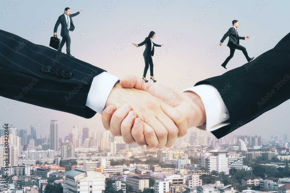 Businesspeople walking on handshake