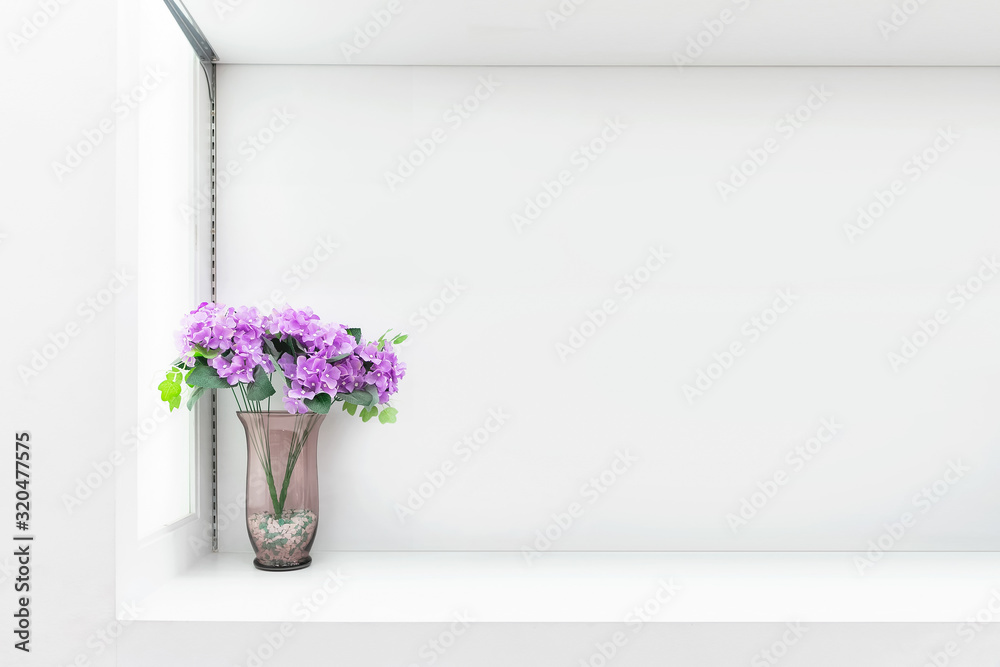 White shelf against white wall with a pot.