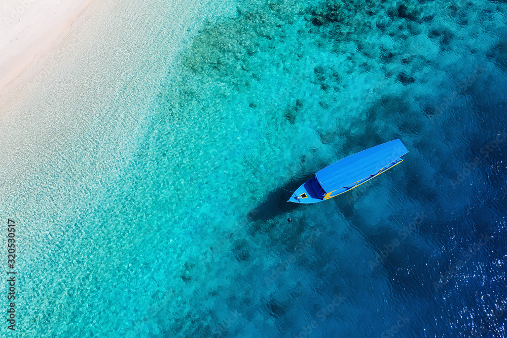 俯视水面和海滩上的船只。无人机拍摄的蓝色背景。夏日海景