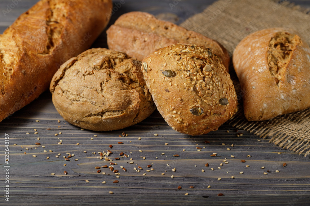 Fresh bread rolls  and baguette closeup  on old wooden table. Rustic concept