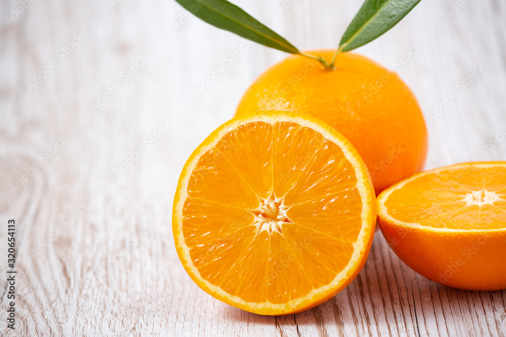 Natural fresh fruit oranges in a wooden background backdrop, half cut oranges, orange juice, vitamin