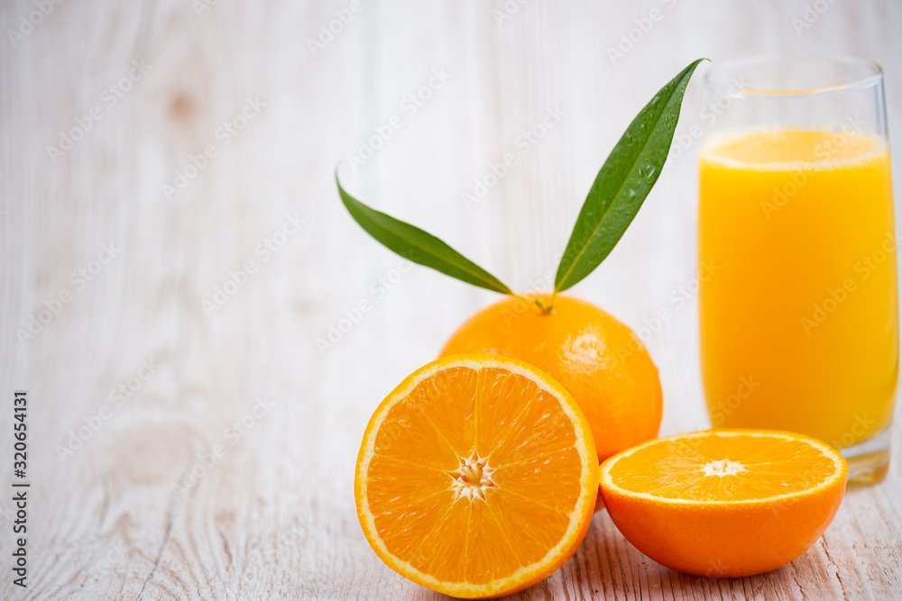 Natural fresh fruit oranges in a wooden background backdrop, half cut oranges, orange juice, vitamin