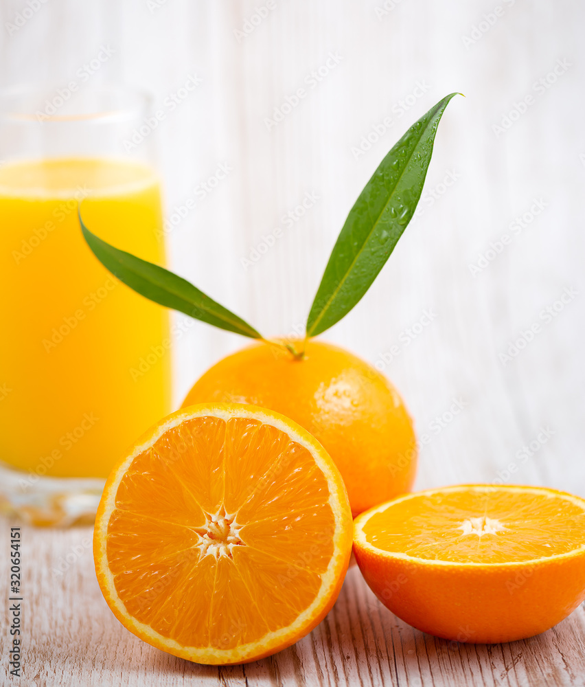 Natural fresh fruit oranges in a wooden background backdrop, half cut oranges, orange juice, vitamin