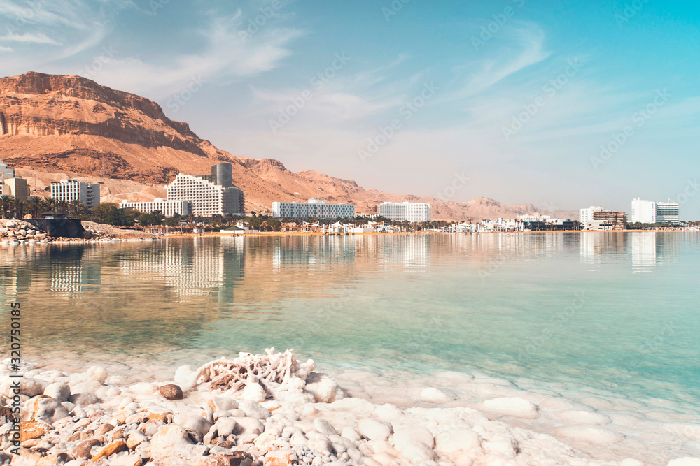 Dead sea salt shore. Salt on background of the sea and the coastal resort town Ein Bokek, Israel