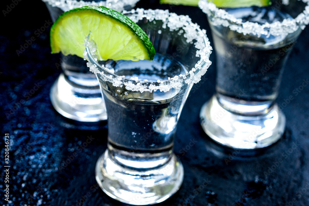 Alcohol shots with lime and salt on black background