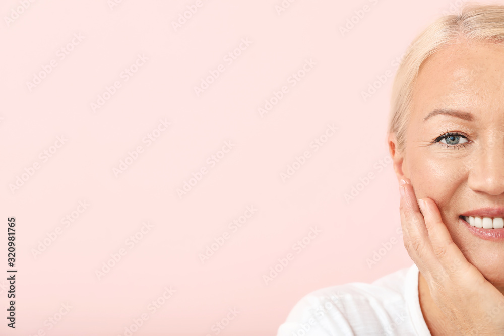 Beautiful mature woman with healthy skin on color background