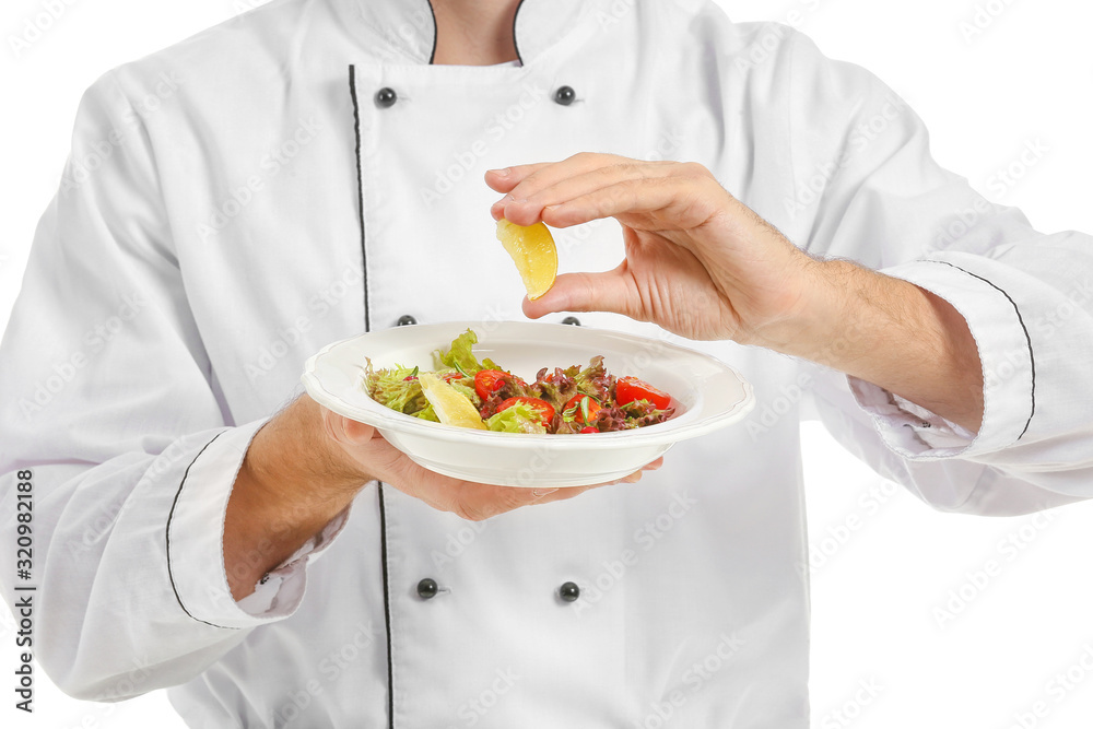 Handsome male chef with prepared dish and piece of lemon on white background, closeup