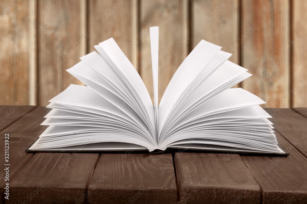 Open book on an old wooden table.