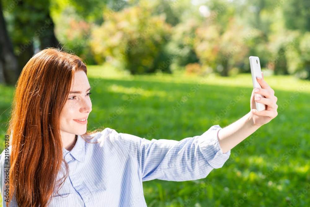 Young redhead woman taking selfie photo