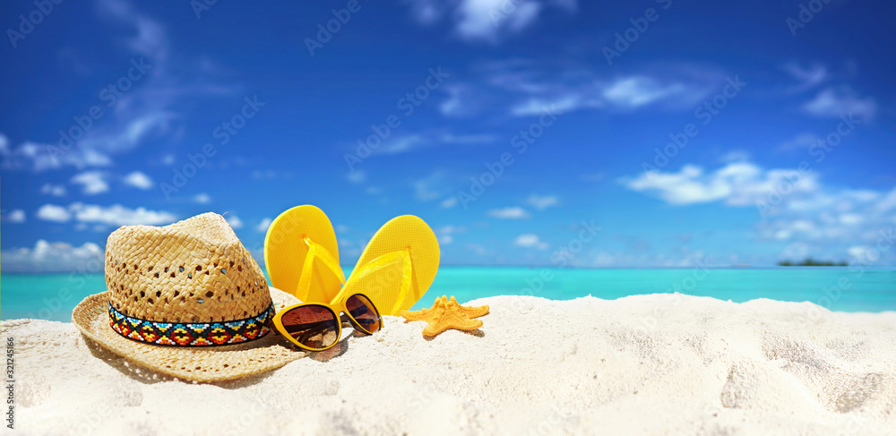 Concept summer beach holiday. Beach accessories - straw hat, glasses, starfish, yellow flip-flops on