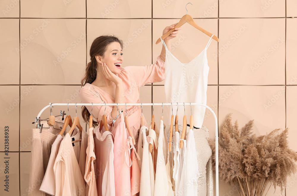 Female stylist near rack with modern clothes