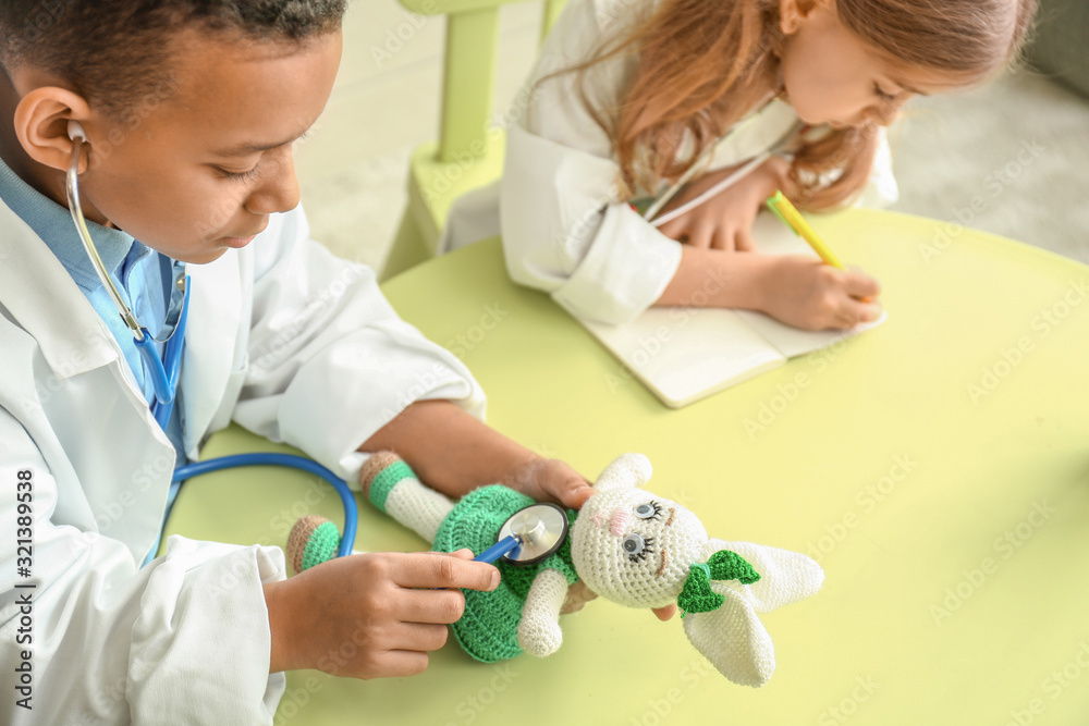 Cute little children dressed as doctors playing at home