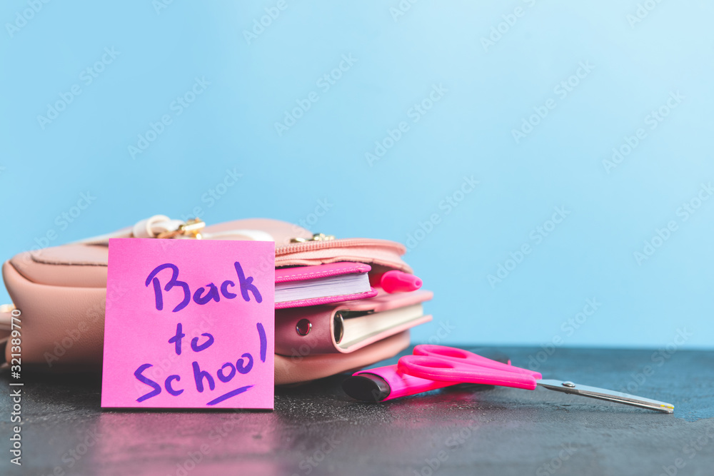 Set of school supplies on table against color background