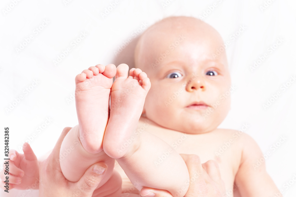 Mother holding logs of infant little baby playing with him view from above