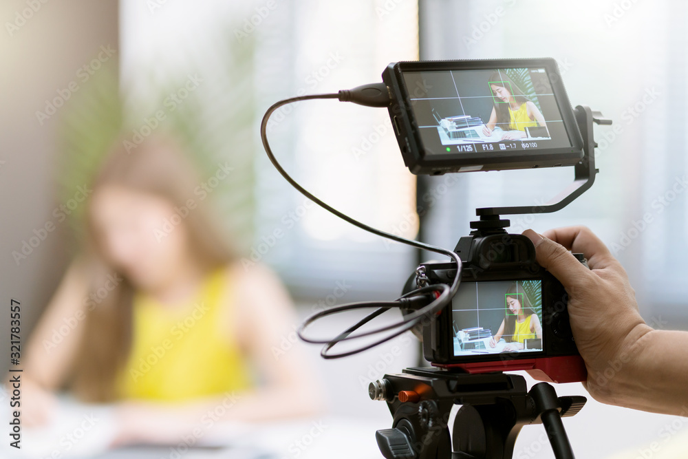 close up camera gear shooting attrative asian female business woman yellow casual dress enjoy workin