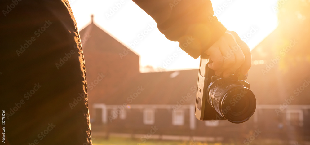 特写亚洲女性手持复古相机旅行者，背景为古老的传统建筑，a