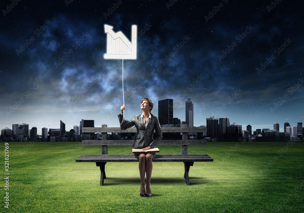 Young woman with open book on wooden bench