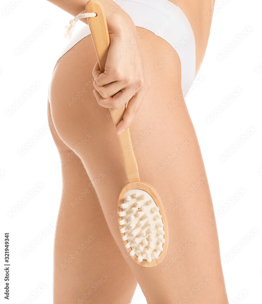 Beautiful young woman with massage brush on white background, closeup