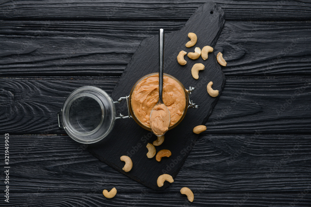 Jar of cashew butter on dark wooden background