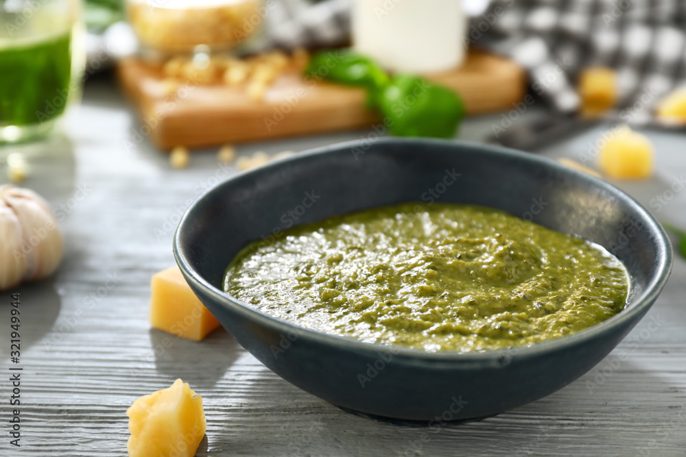 Bowl with pesto sauce on table