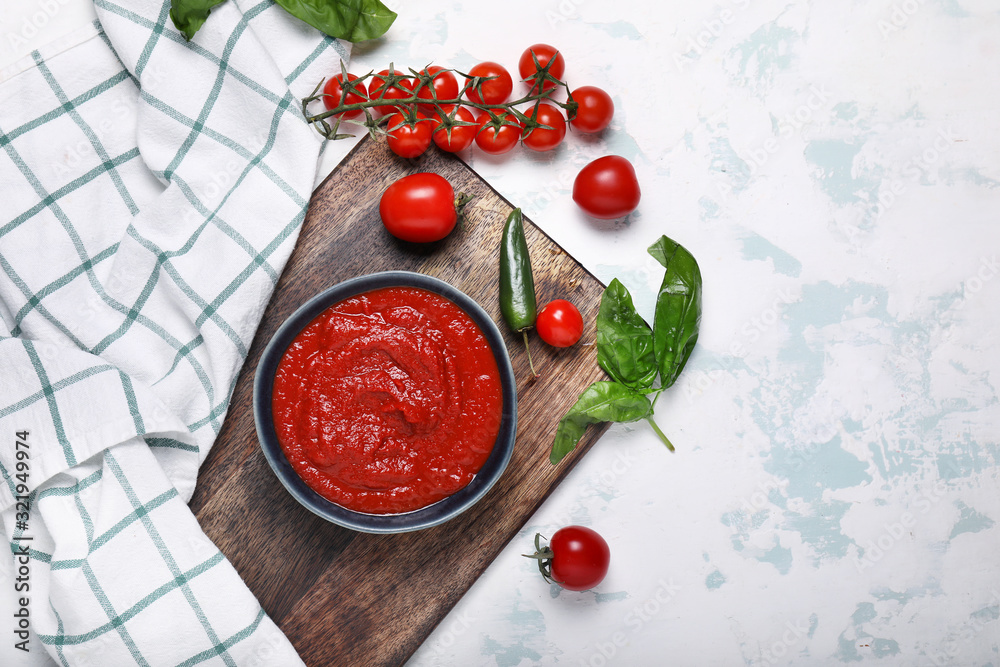 Bowl with tomato sauce on white background