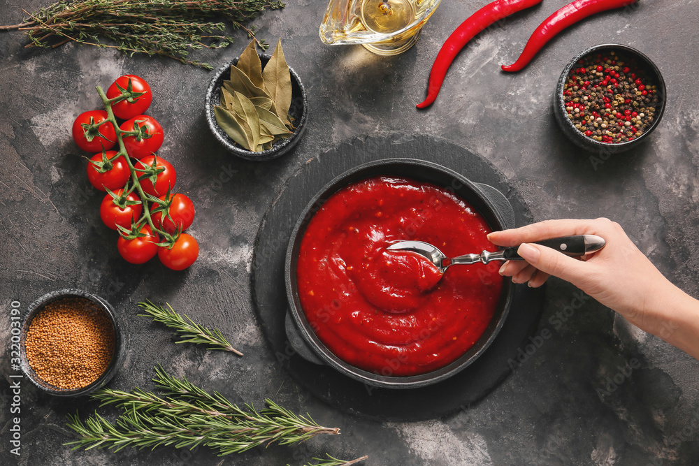 Woman preparing tomato sauce in pan