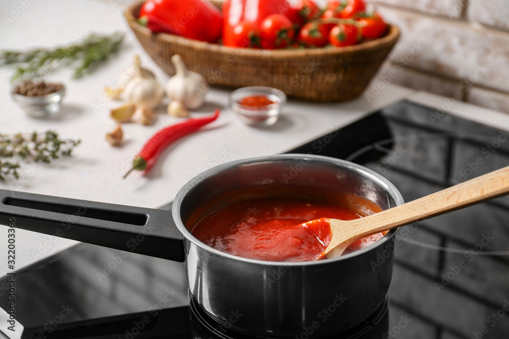 Preparing of tomato sauce in saucepan